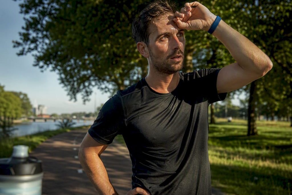 Hardloper veegt zweet weg tijdens een warme duurploop