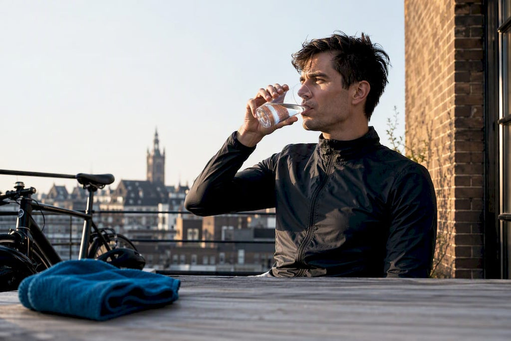 Stadsbewoner drinkt water na het sporten