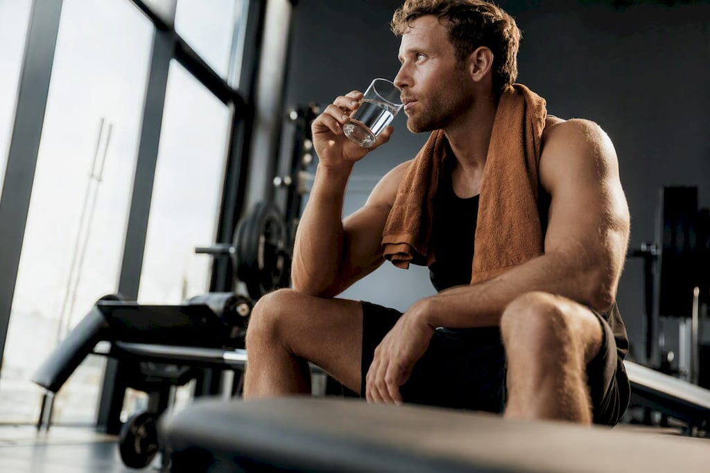 Atleet drinkt water tussen de krachtsets door