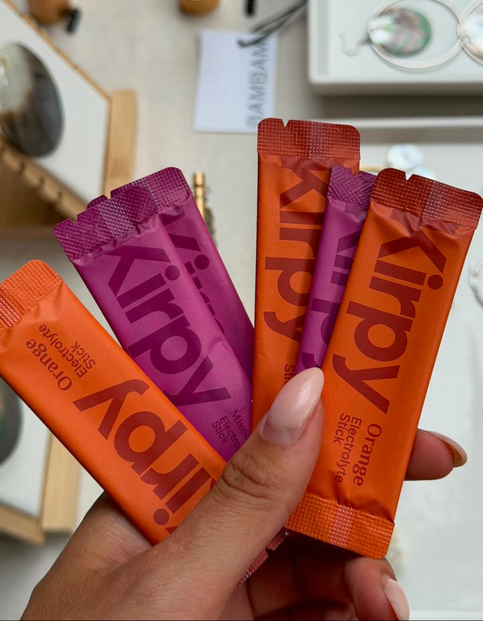 Kirpy Orange en Mixed Berries electrolyte sticks in de hand