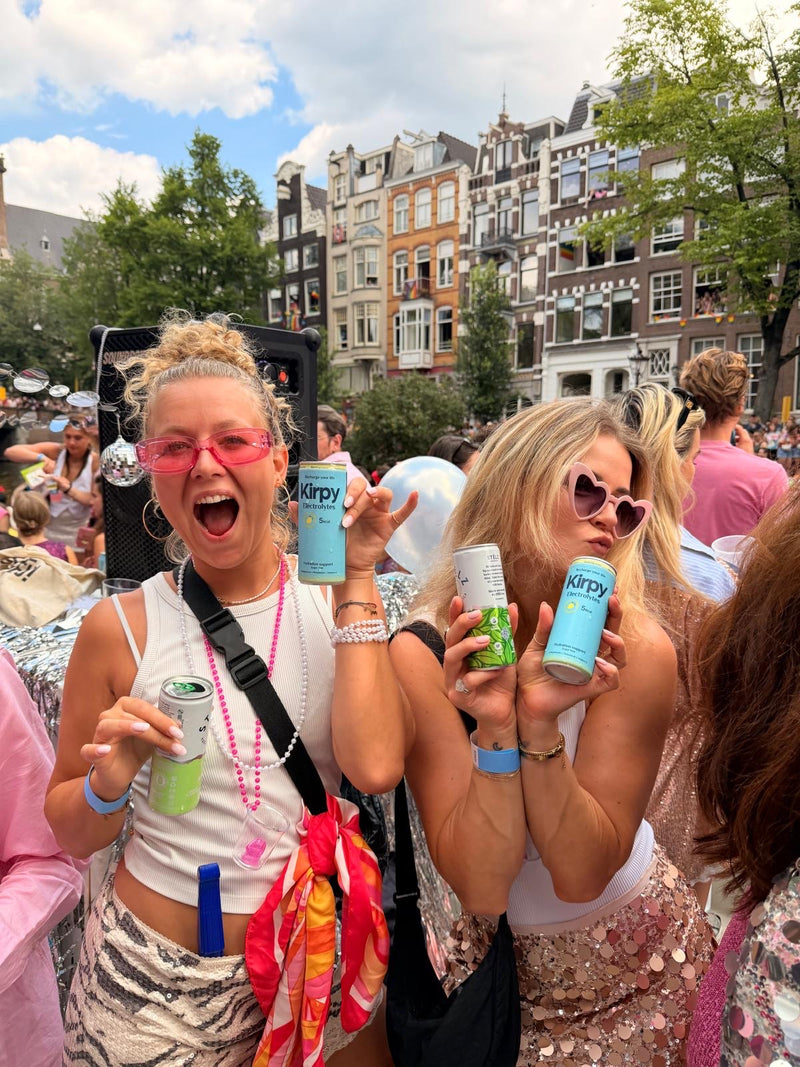 Twee vrouwen met Kirpy blikjes tijdens een optocht in Amsterdam